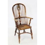 An early 19th century elm and ash hoop back Windsor farmhouse elbow chair, with a central pierced