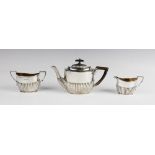 A matched silver three-piece bachelor tea service, comprising a teapot, sucrier and milk jug, each