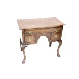 A George III style oak lowboy, the rectangular moulded top above an arrangement of one long and