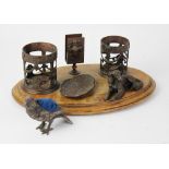 An early 20th century bronzed metal desk tidy, with two open work cylindrical ink pot wells, a vesta