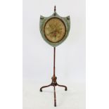 An early 19th century satinwood pole screen, the shield shaped screen with a glazed oval