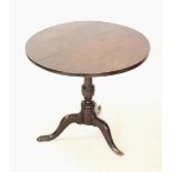 A George III oak tripod table, the four plank tilt top, raised upon a ring turned pedestal extending