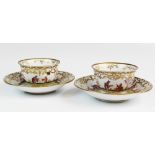 A pair of hard paste porcelain tea bowls and saucers, decorated in the manner of Johann Gregorius