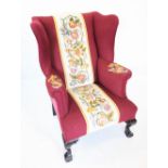 A George III style wing back fireside armchair, late 19th/early 20th century, in burgundy fabric