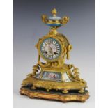 A late 19th century French gilt metal and porcelain inset mantel clock, the two handled urn finial