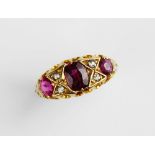 An early 20th century ruby and diamond 18ct gold ring, the central untested oval mixed cut ruby