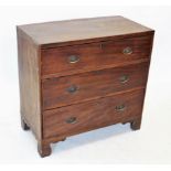 An early 19th century mahogany chest of drawers, with an arrangement of three graduated and cock