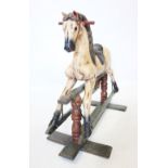 A carved wooden child's rocking horse, 20th century, naturalistically modelled and painted, with