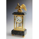 A late 19th century French Empire style four glass clock, surmounted with gilt metal eagle with