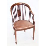 An Edwardian mahogany tub chair, the down swept top rail above a central pierced splat inlaid with