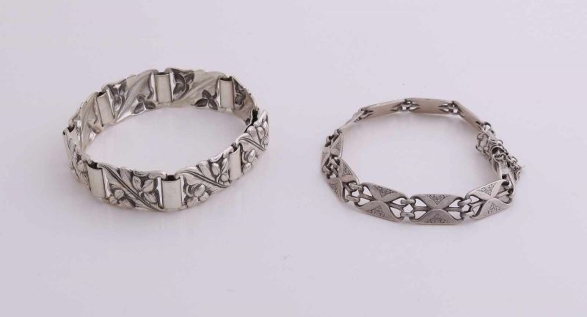 Two silver bracelets 800/000 made of rectangular links with floral decoration. One bracelet features