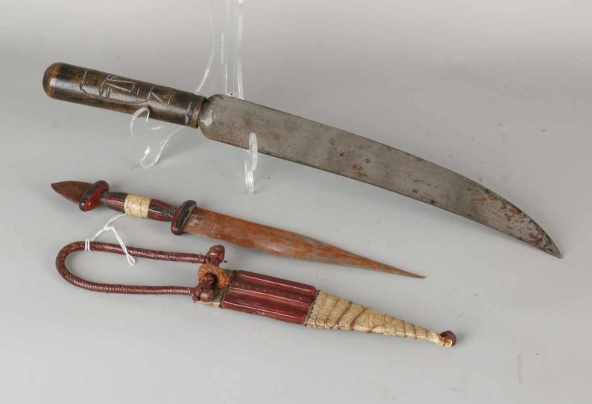 Two old / antique Oriental knives. Among other things, covered with leather. Size: 32 to 46 cm. In