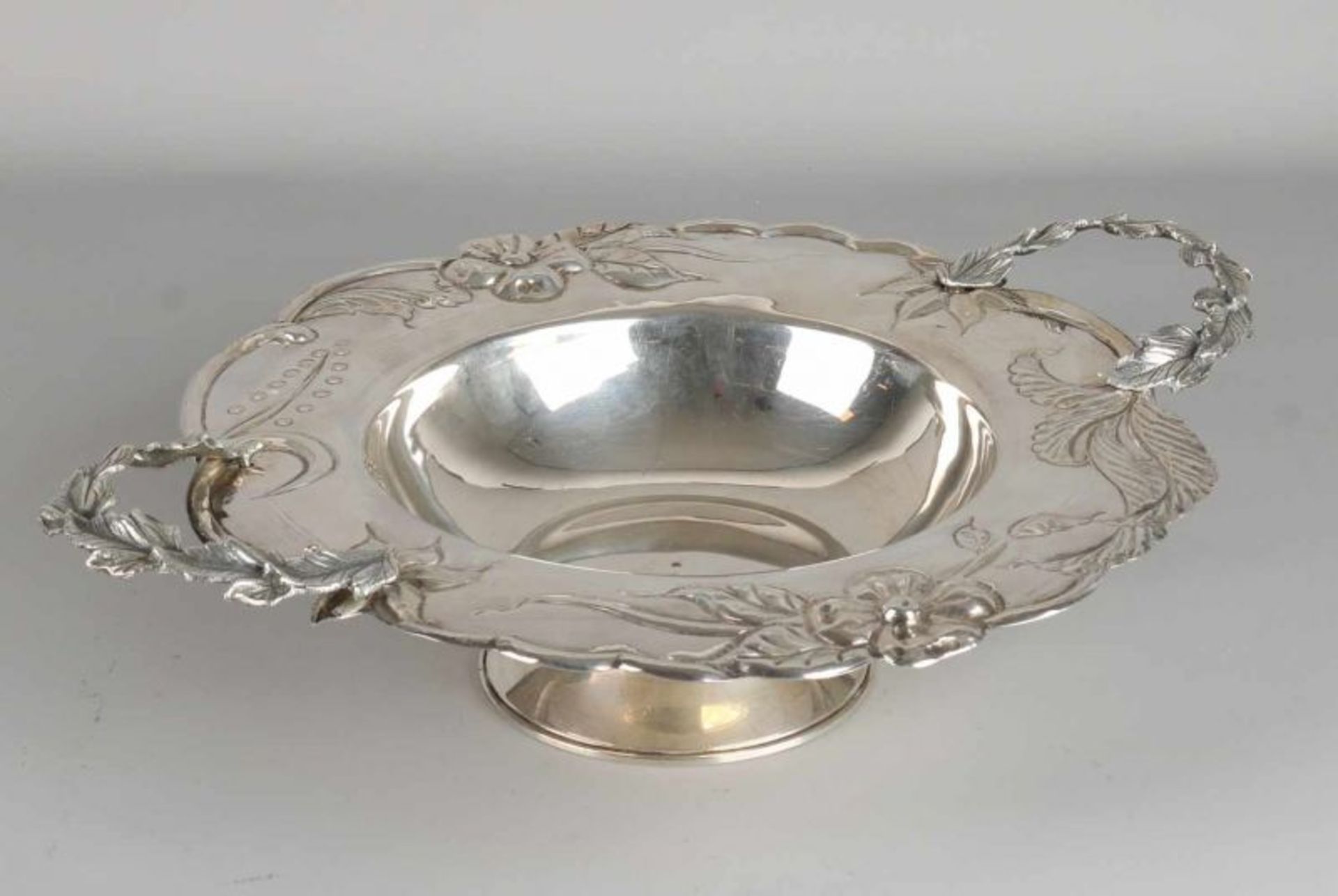 Fine silver platter, 835/000, round model with a molded edge with floral decoration, set on a