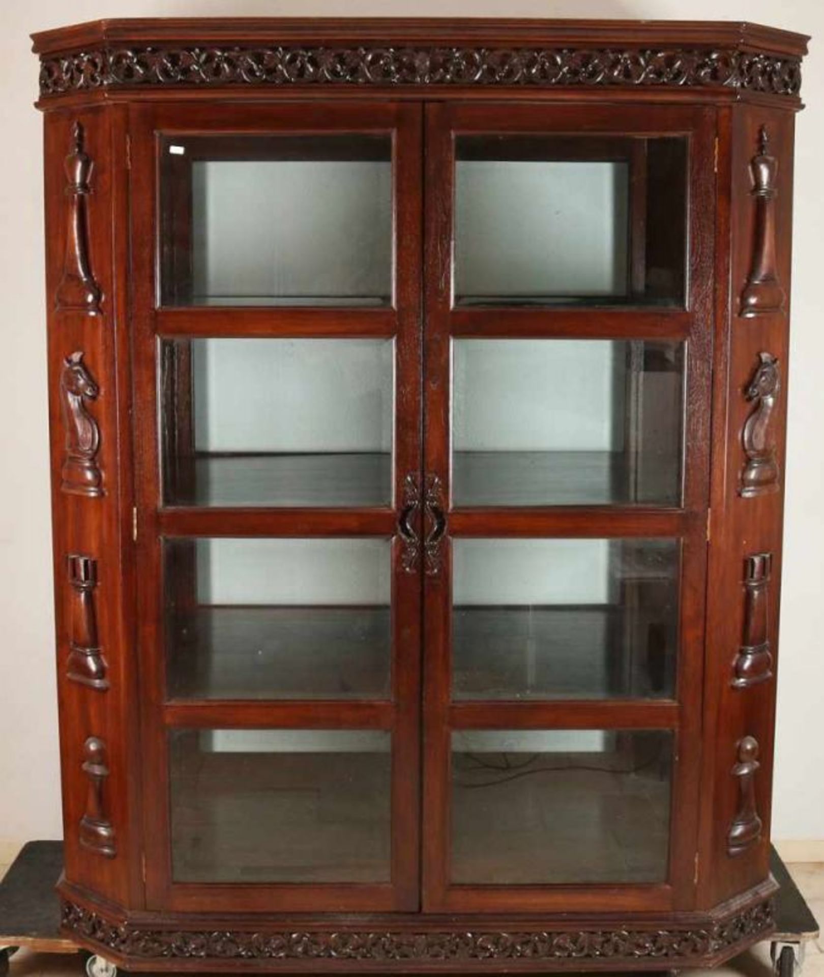 Octagonal teak two-door display cabinet with faceted glass and chess pieces cut figures. Second half