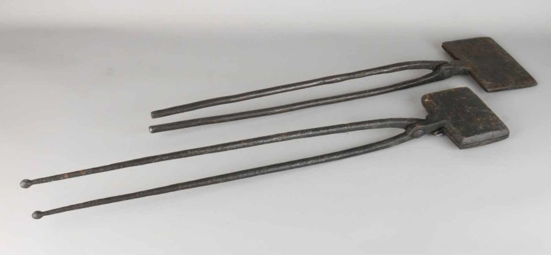 Two 19th-century wrought-iron waffle irons. Size: 70-76 cm. In good condition.
