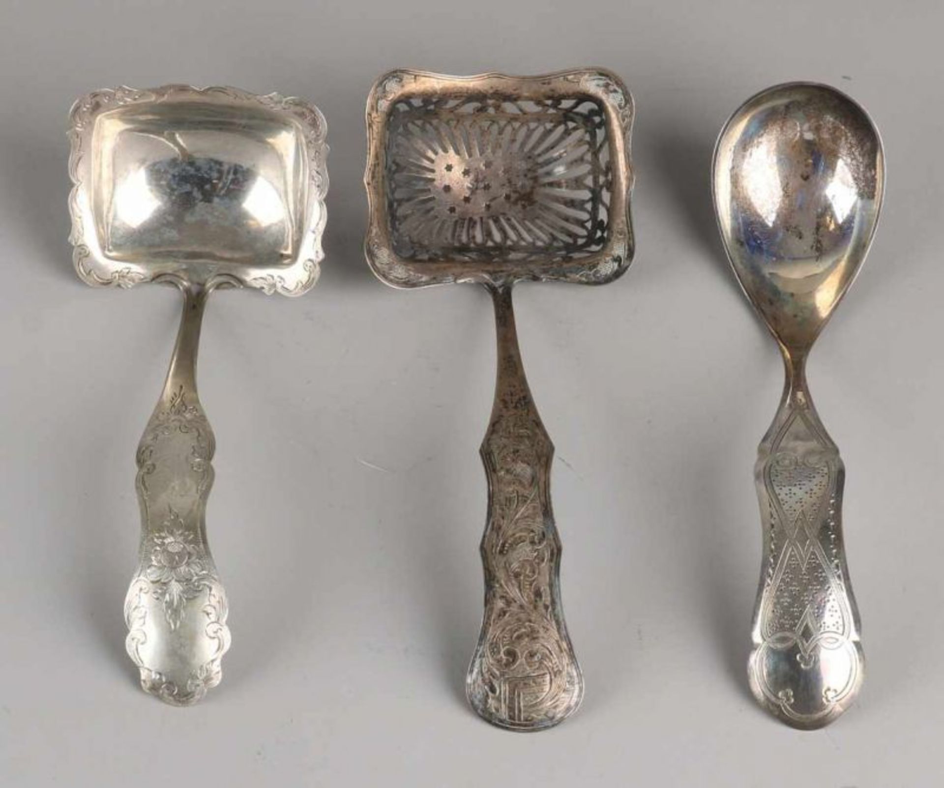 Three silver spoons, 833/000, with a sprinkle spoon with a rectangular open-work molded container is