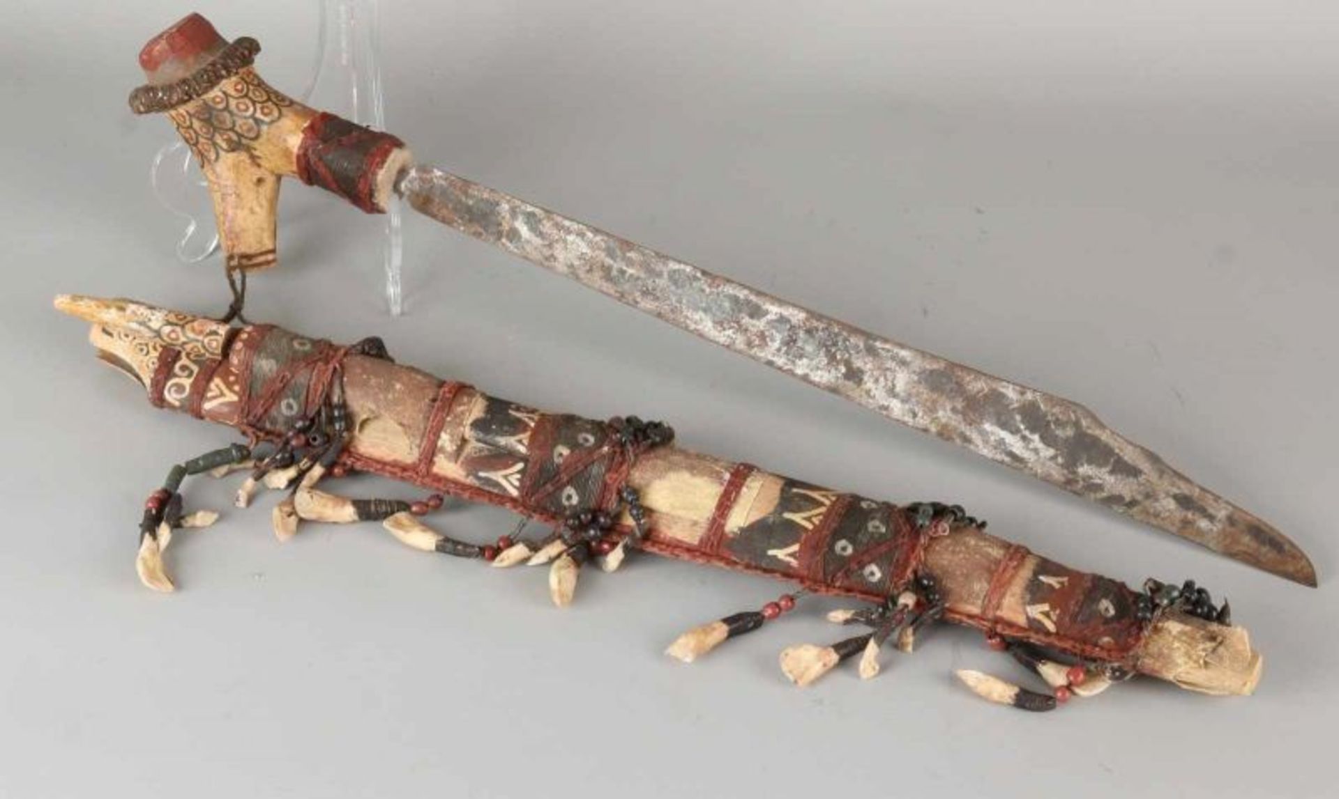 Old polychrome headhunter knife Borneo. Adorned with teeth. Size: L 62 cm. In good condition.