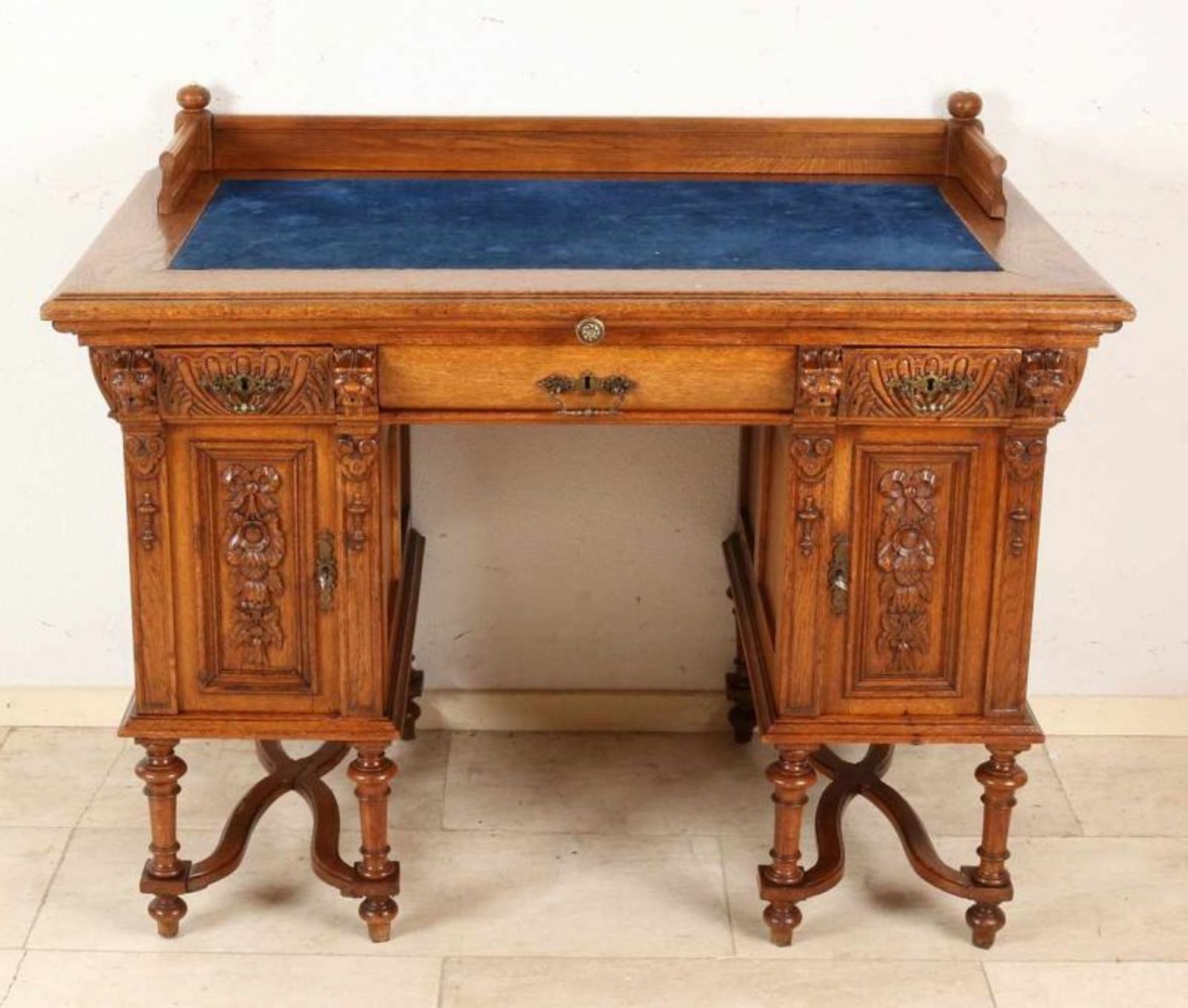 19th Century oak historicism writing desk with lion heads, three drawers and crossed legs. Circa