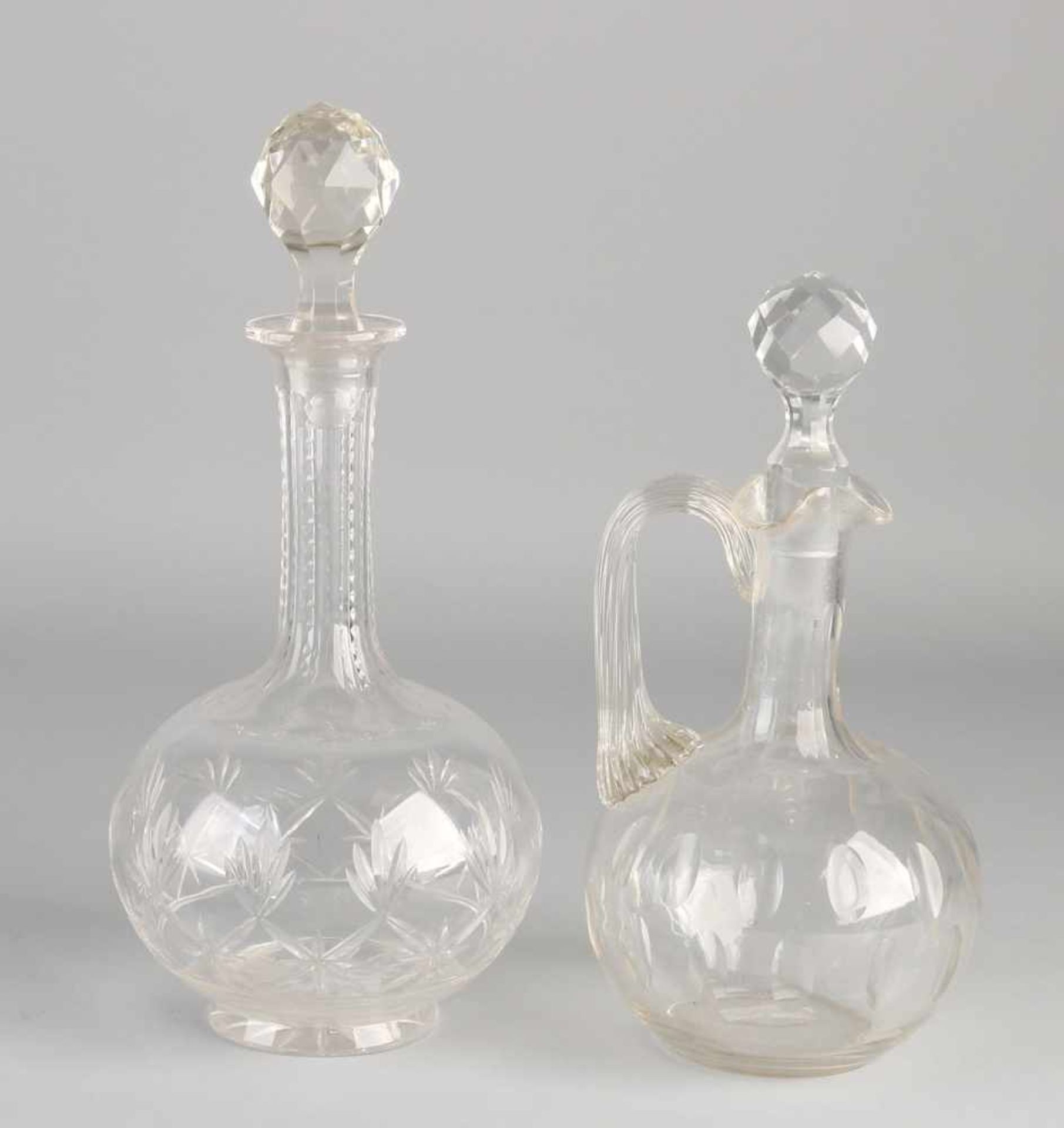 Two antique crystal decanters. One meal with almond sharps. One times with floral facet grindings.