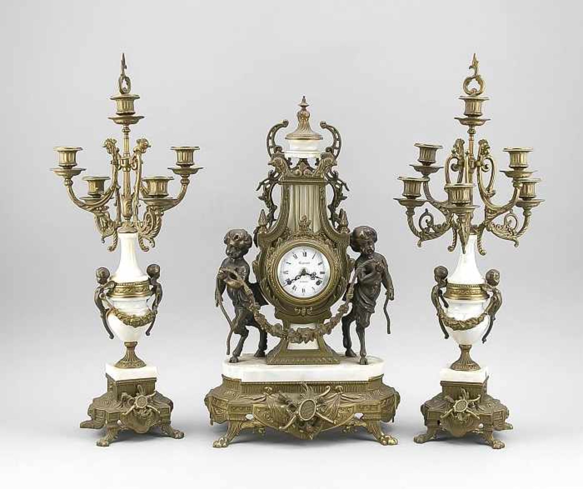 Three-piece set of pendulum. Marble and putti. 20th century. Movement in lyre form. Regnant a.