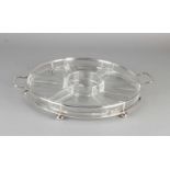 Round glass serving dish with distribution boxes placed in a silver round container 6 ball feet.