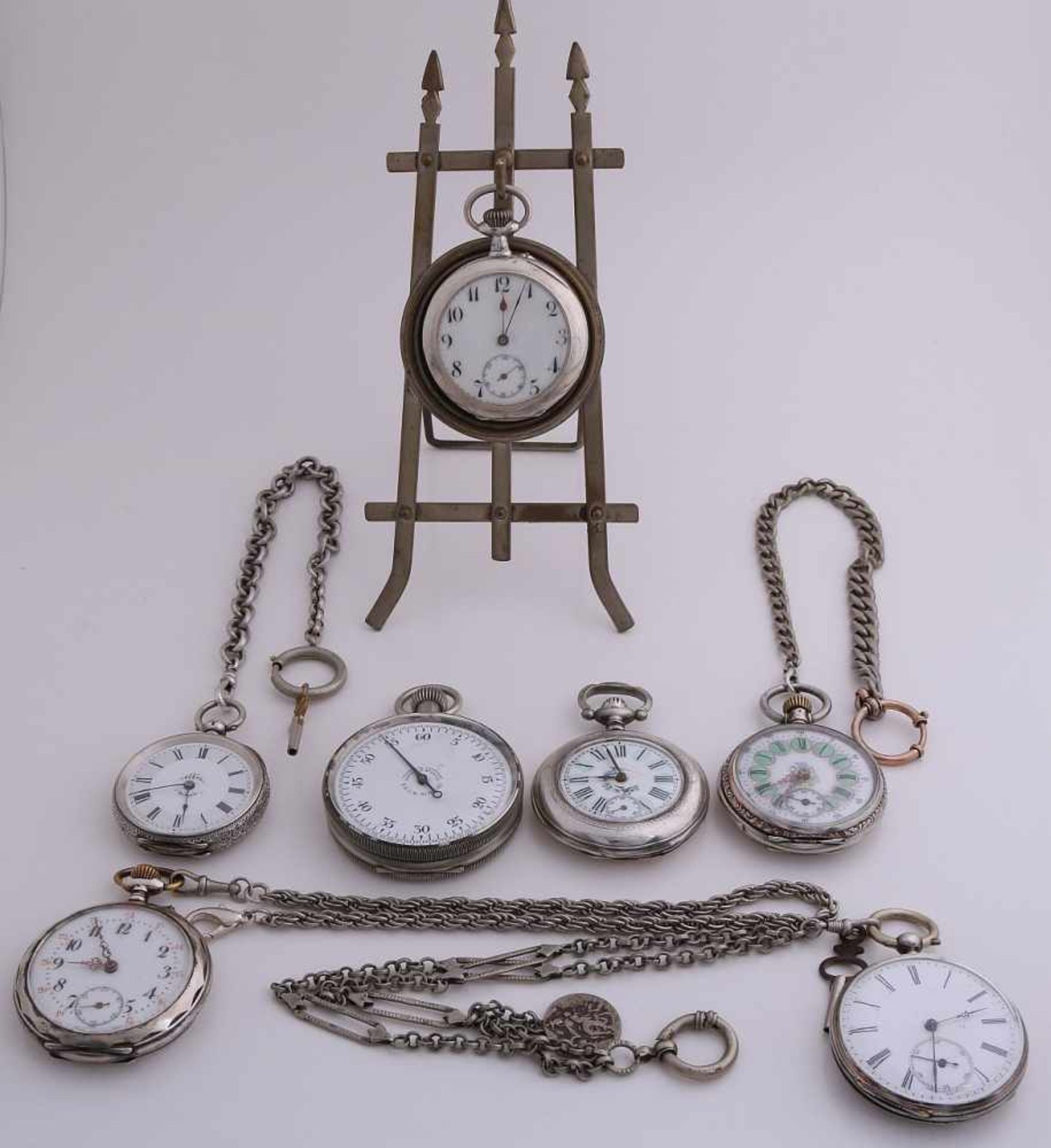 Lot 6 antique pocket watches, stop watch and a holder. Partly silver and four watch chains. In