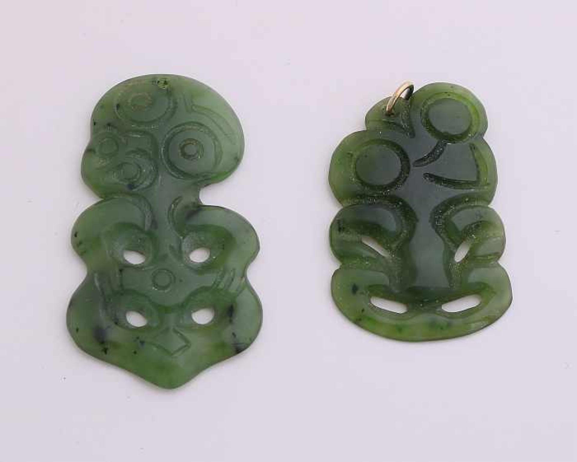 Two carved jade pendants, one with hanging eye. 24x46mm and 25x46mm. In good condition