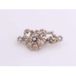 White gold brooch, 585/000 with diamond. Ornate brooch with curls and flowers set with brilliant cut