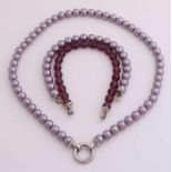 Perlenkette, Perlenarmband und ein Armband aus facettierten Perlen, alle lila, mit einem silbernen