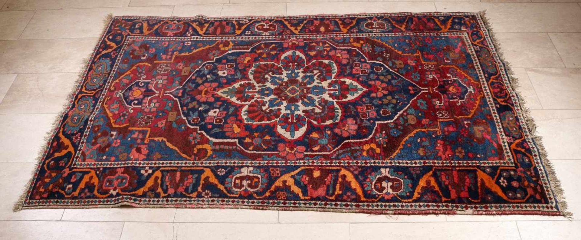 Handgeknüpfter Teppich in den Farben Rot / Blau mit einem großen Medaillon in der Mitte. Größe: