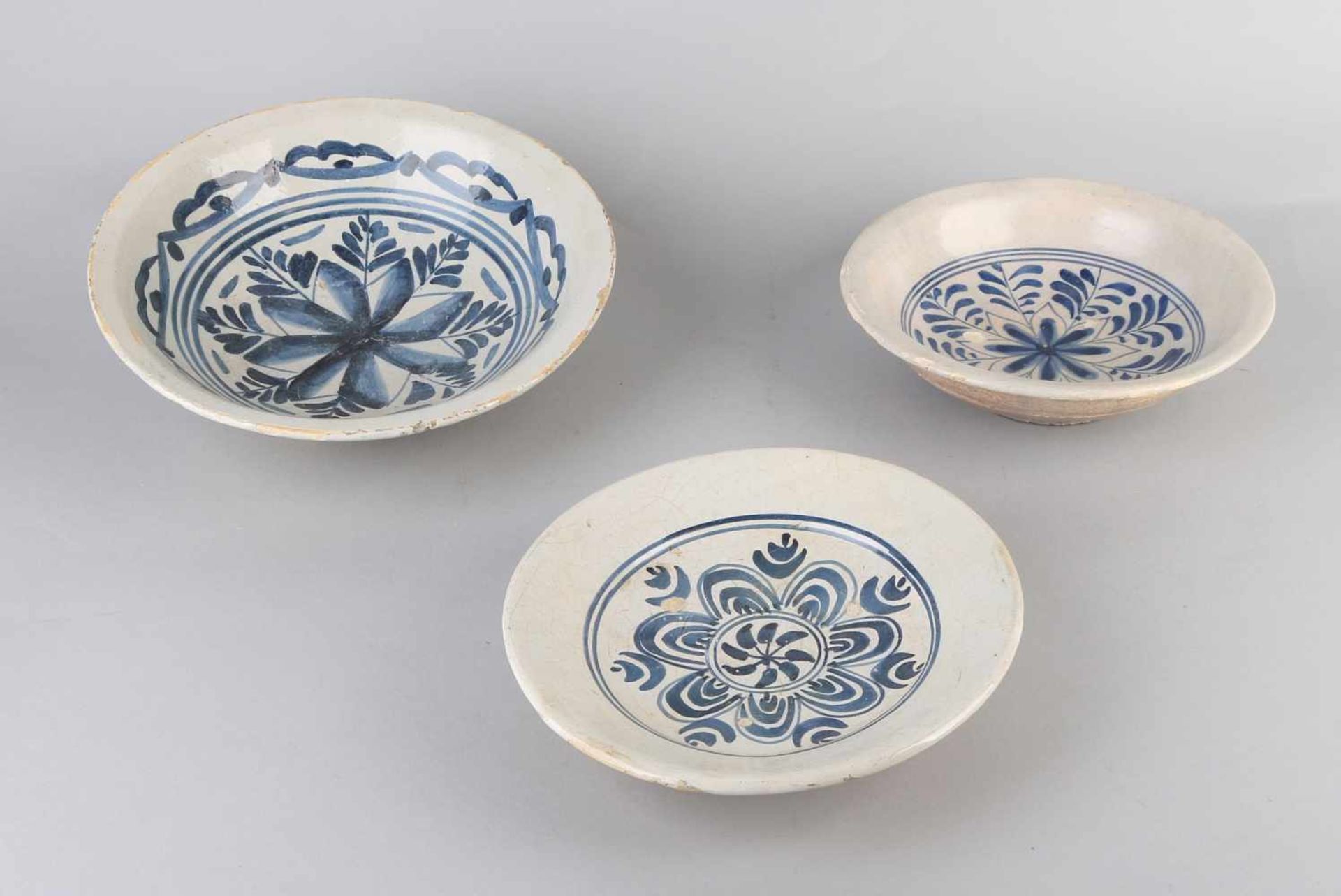 Drei Delfter Gerichte aus dem 18. Jahrhundert mit Blumendekor. Kantenrestaurationen. Größe: Ø 22 -