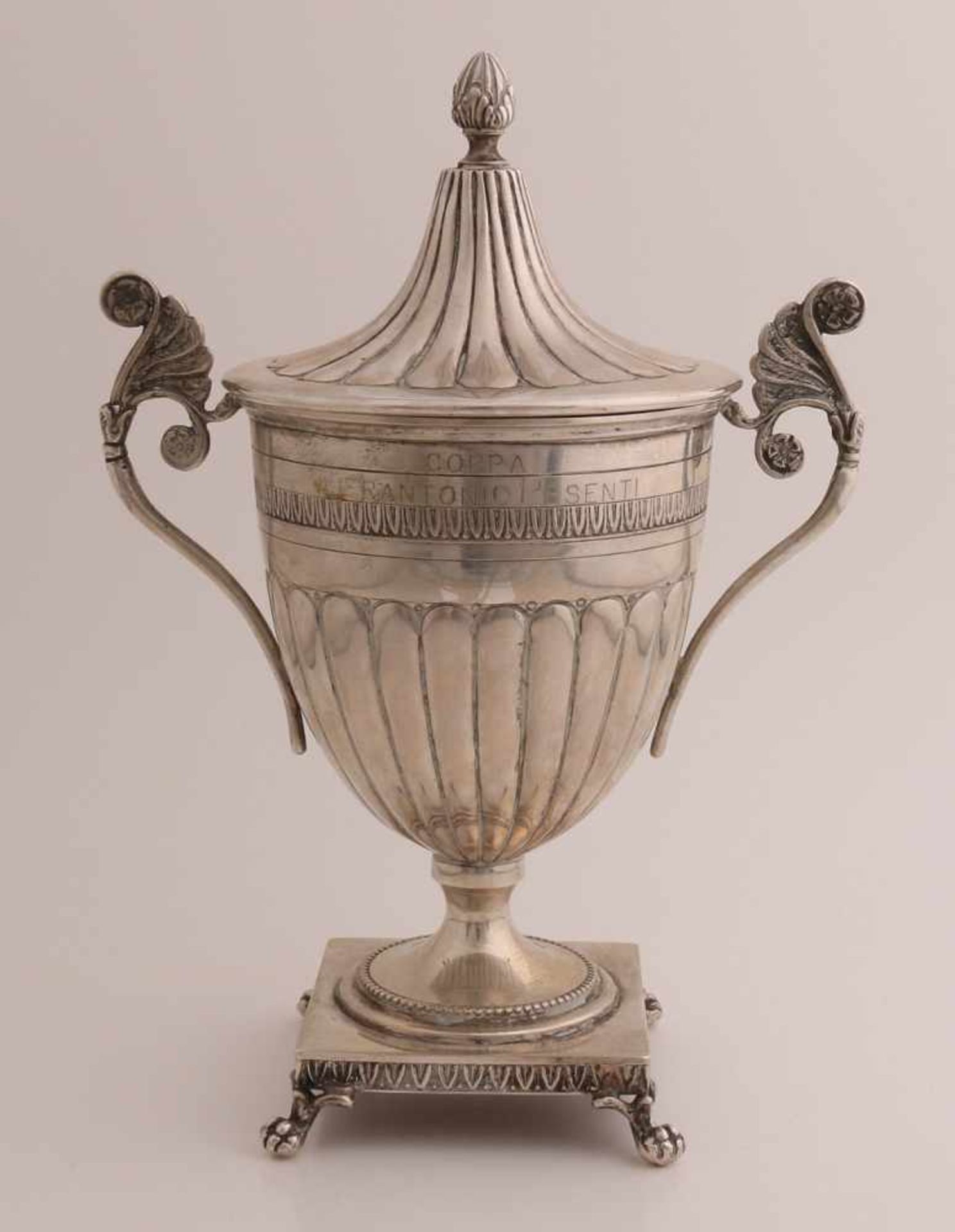 Silberne Trophäe mit Deckel, 800/000. Ein Glas mit Flöten, ebenfalls auf dem Deckel, mit