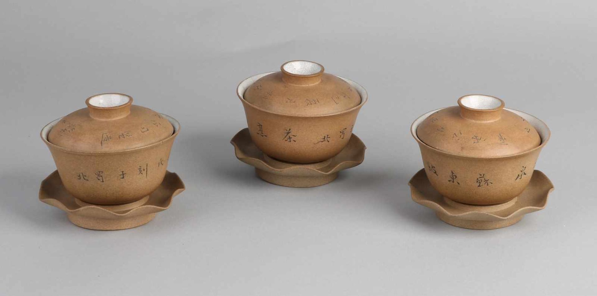 Drei separate dreiteilige Tassen aus chinesischem Porzellan mit Teeglasur und Reißverschlusstext.