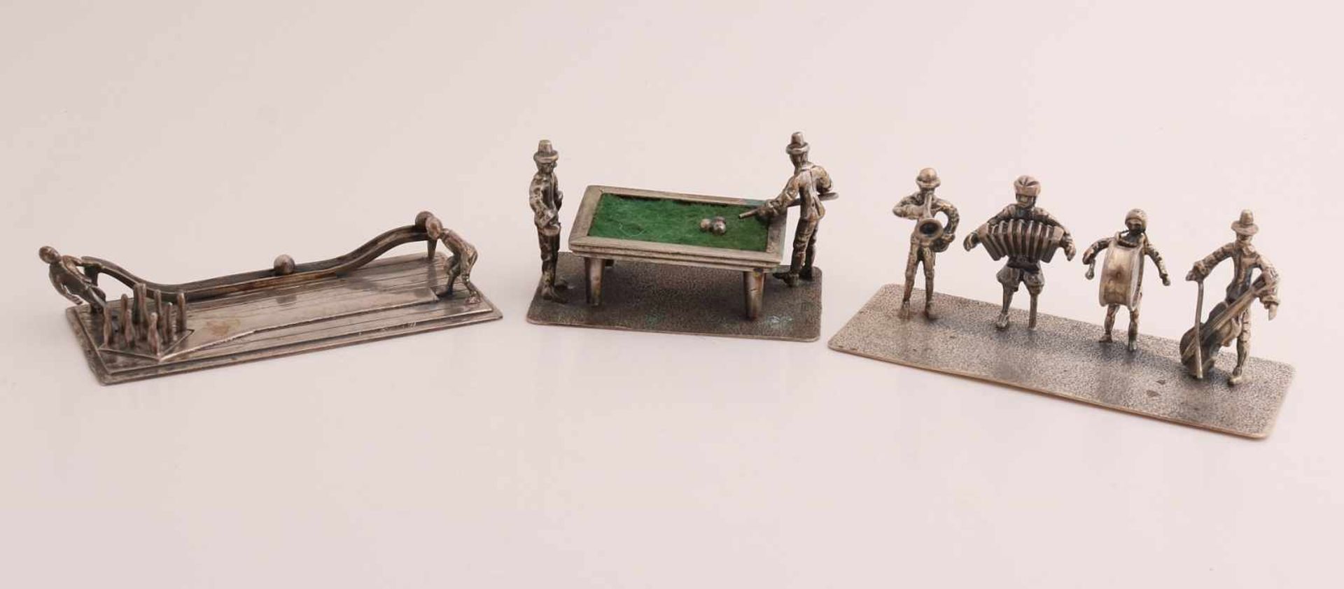 Drei silberne Miniaturen, 835/000, auf Teller, mit einer Kegelbahn mit Figuren, 7x3x2cm, einem