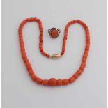 Halskette und Ring mit roter Koralle. Eine Halskette aus abgestuften tonnenförmigen roten