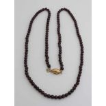 Lange Halskette aus facettierten Granatperlen, ø 7 mm, befestigt an einem olivfarbenen