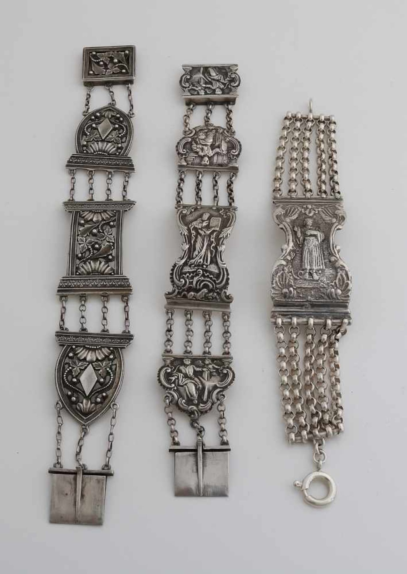 Drei silberne Armbänder, 833/000, aus Bibelverschlüssen, mit Figuren und Blumendekor. Insgesamt