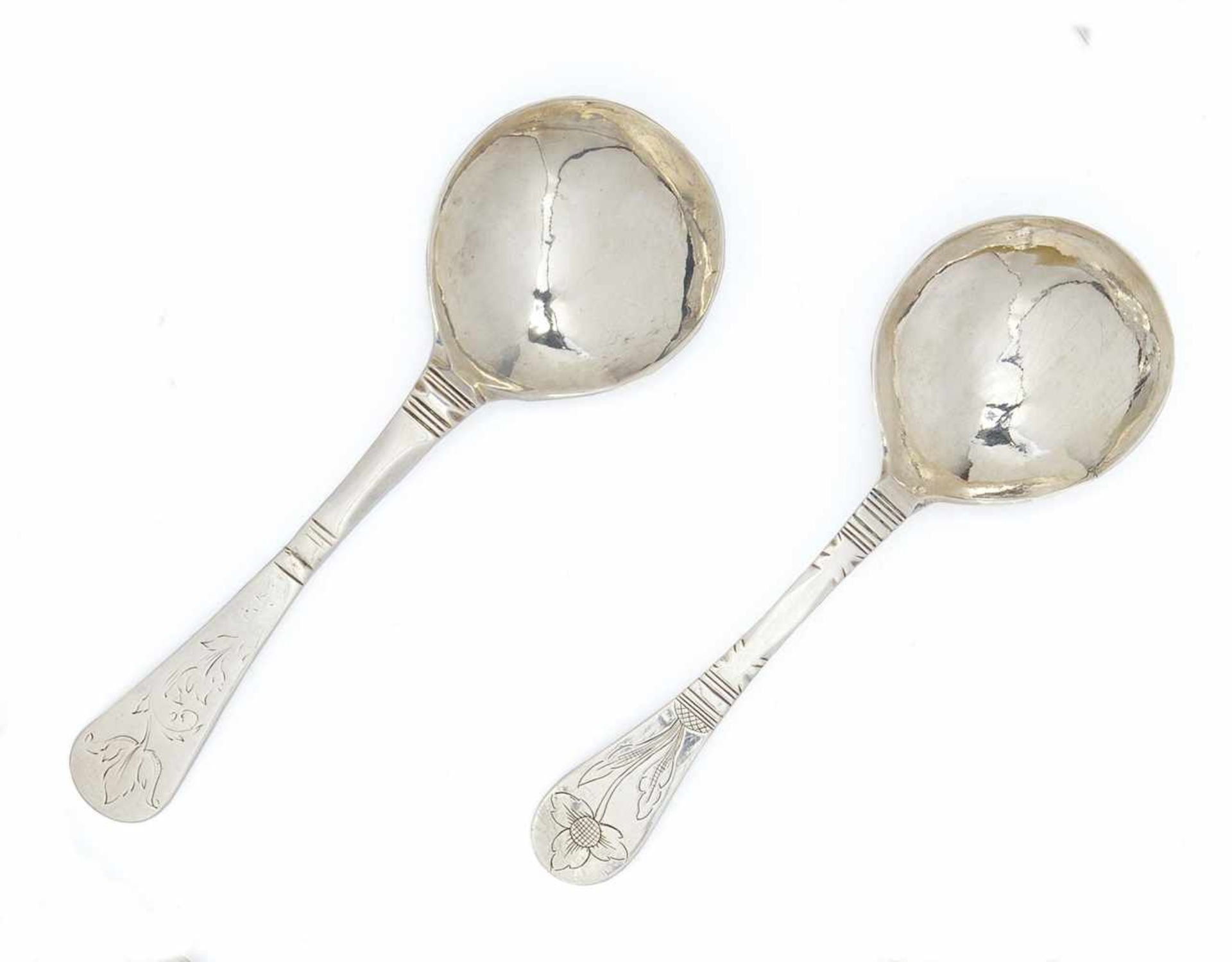 TWO SILVER SPOONS WITH FLORAL ENGRAVINGS.