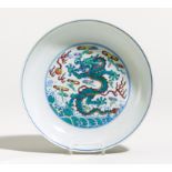 DISH WITH DRAGON ABOVE WAVES. Origin: China. Technique: Porcelain painted in doucai. On the