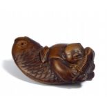 NETSUKE: KARAKO GRABBING A BIG FISH BY ITS TAIL. Origin: Japan. Date: 18th/19th c. Technique: Dark