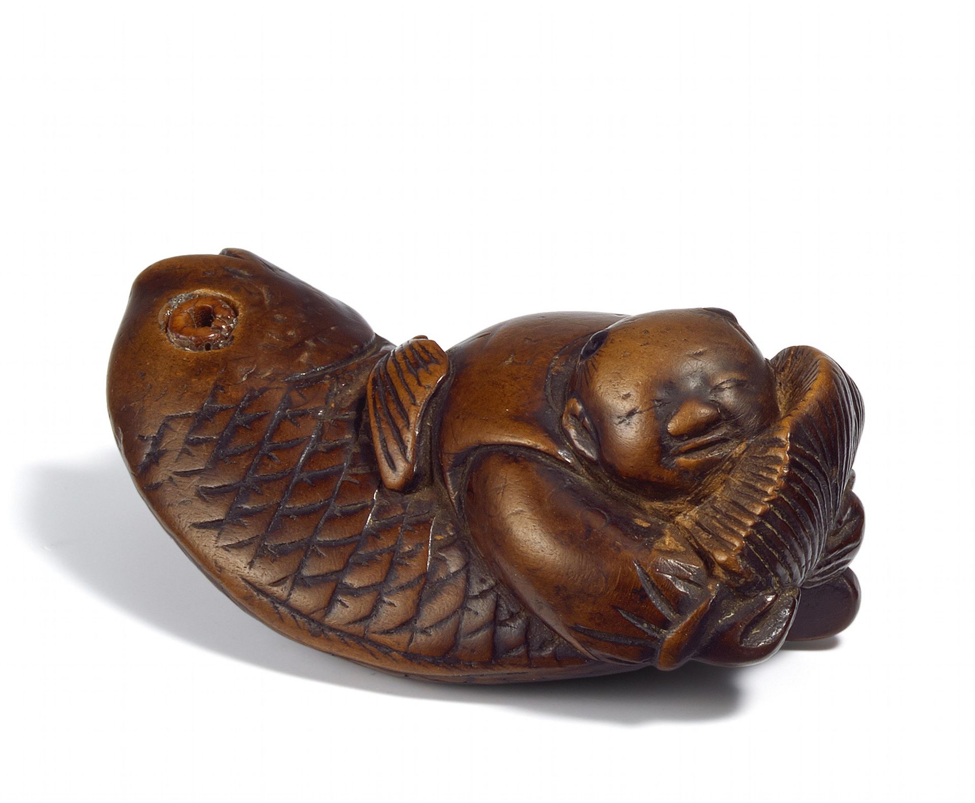 NETSUKE: KARAKO GRABBING A BIG FISH BY ITS TAIL. Origin: Japan. Date: 18th/19th c. Technique: Dark