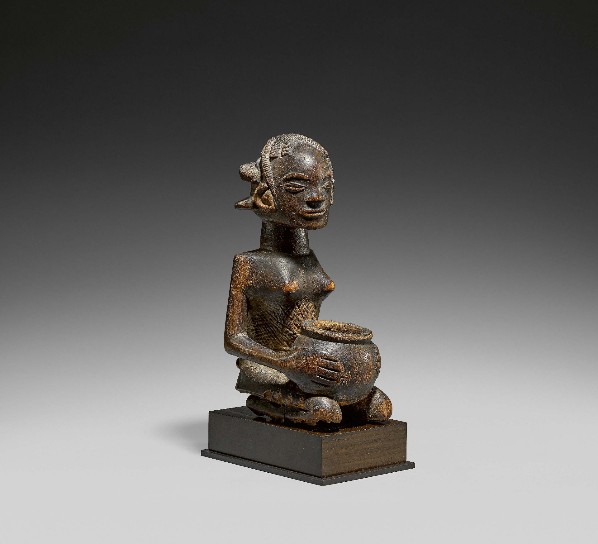 LUBA, Demokratic Republic of the Congo. Woman carrying a bowl. Wood, brown patina. 34 x 15,5 x 21,