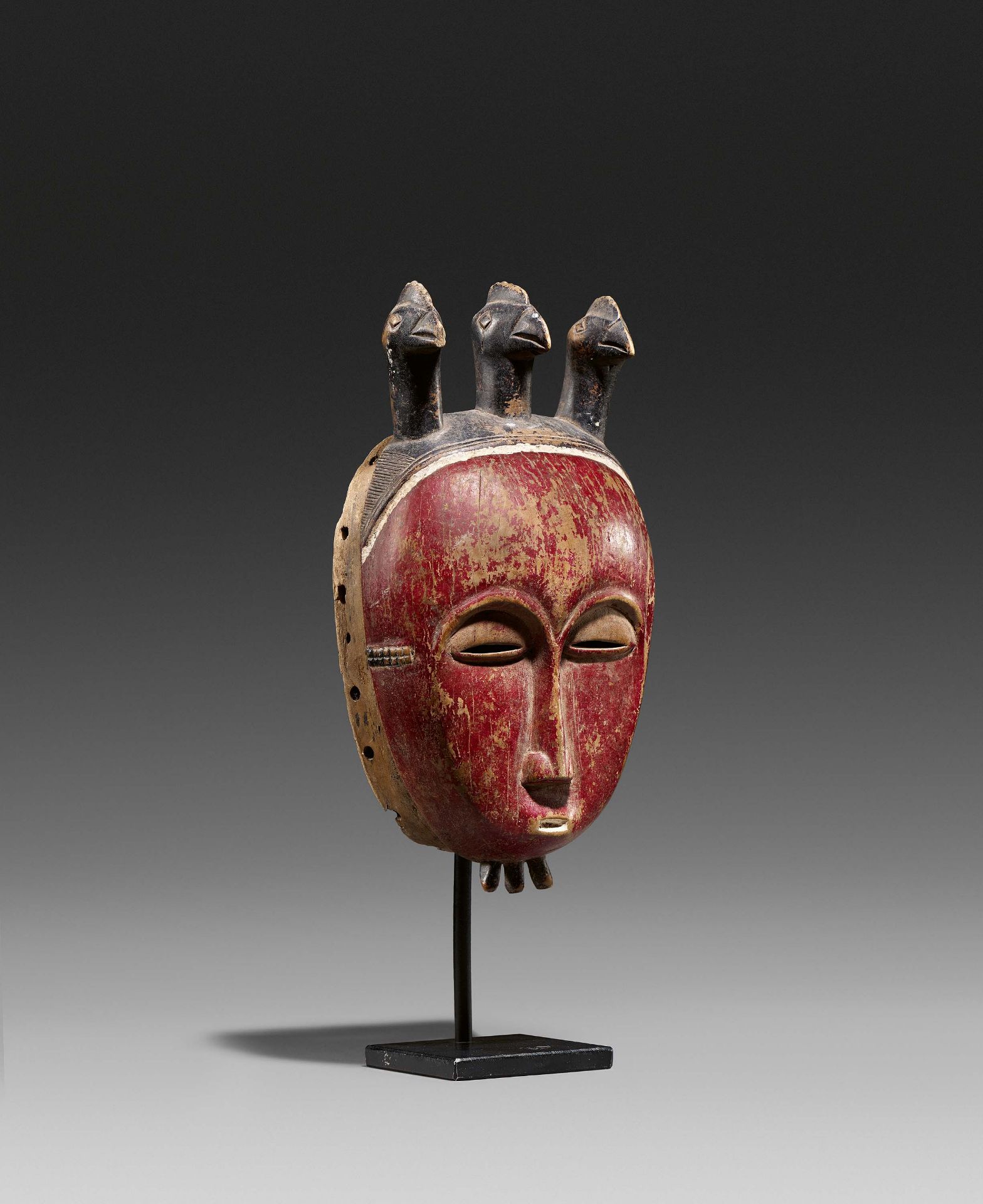 BAULE, Ivory Coast. Mask. Wood, red painted decoration. 26 x 14 x 8cm. Metal stand (24 x 11,5 x 8,