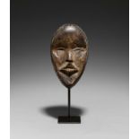 DAN, Ivory Coast. Mask. Wood, polished black. 22 x 13 x 6cm. Metal stand (25 x 11 x 8cm; total