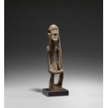 DOGON, Mali. Seated male figure. 19th/Early 20th century. Wood, old patina. 35 x 7,5 x 9cm. Wooden