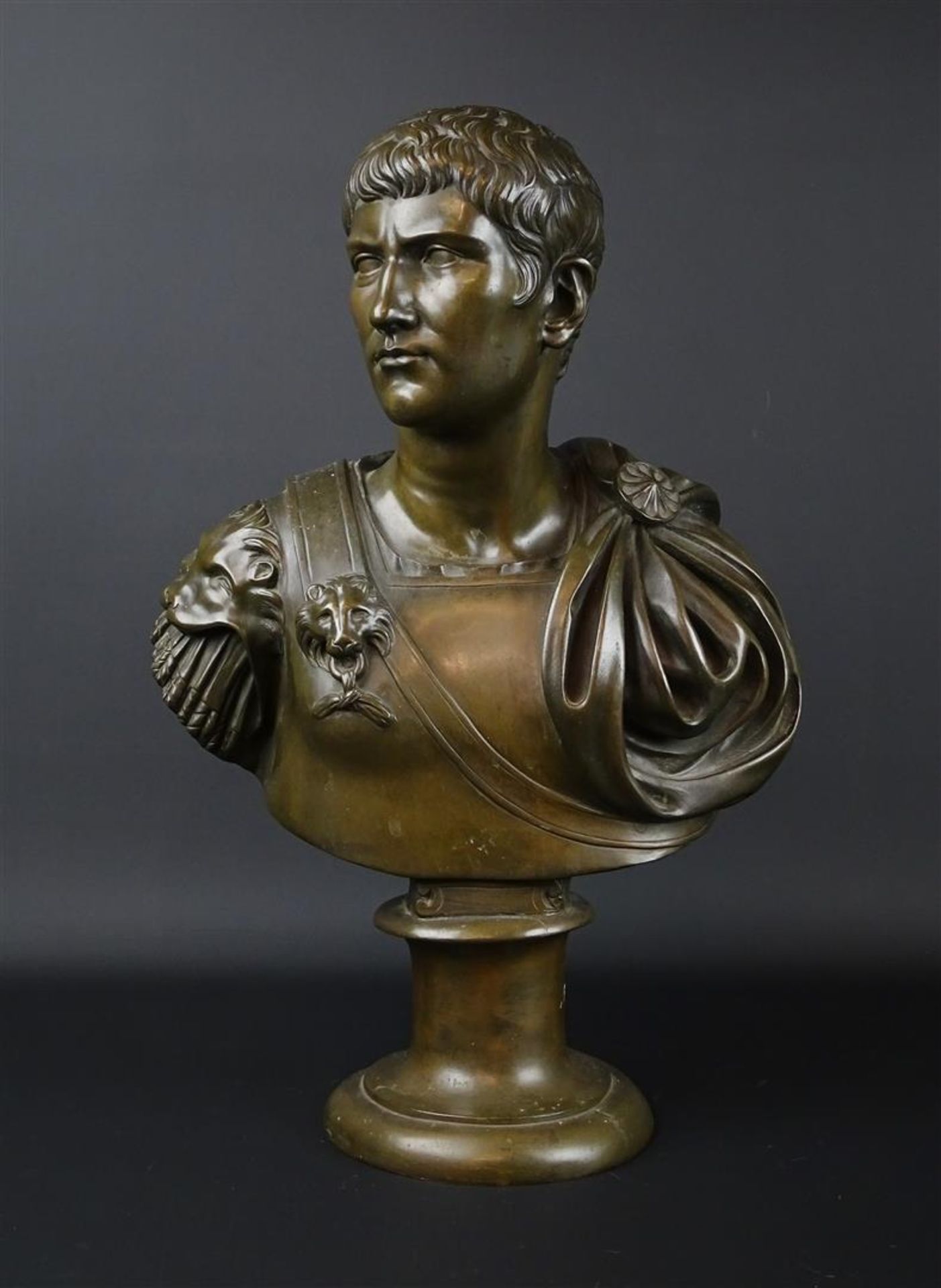 bronzen buste met voorstelling van een Romeinse keizer op ronde voet, niet gesigneerd, h. 47 cm.