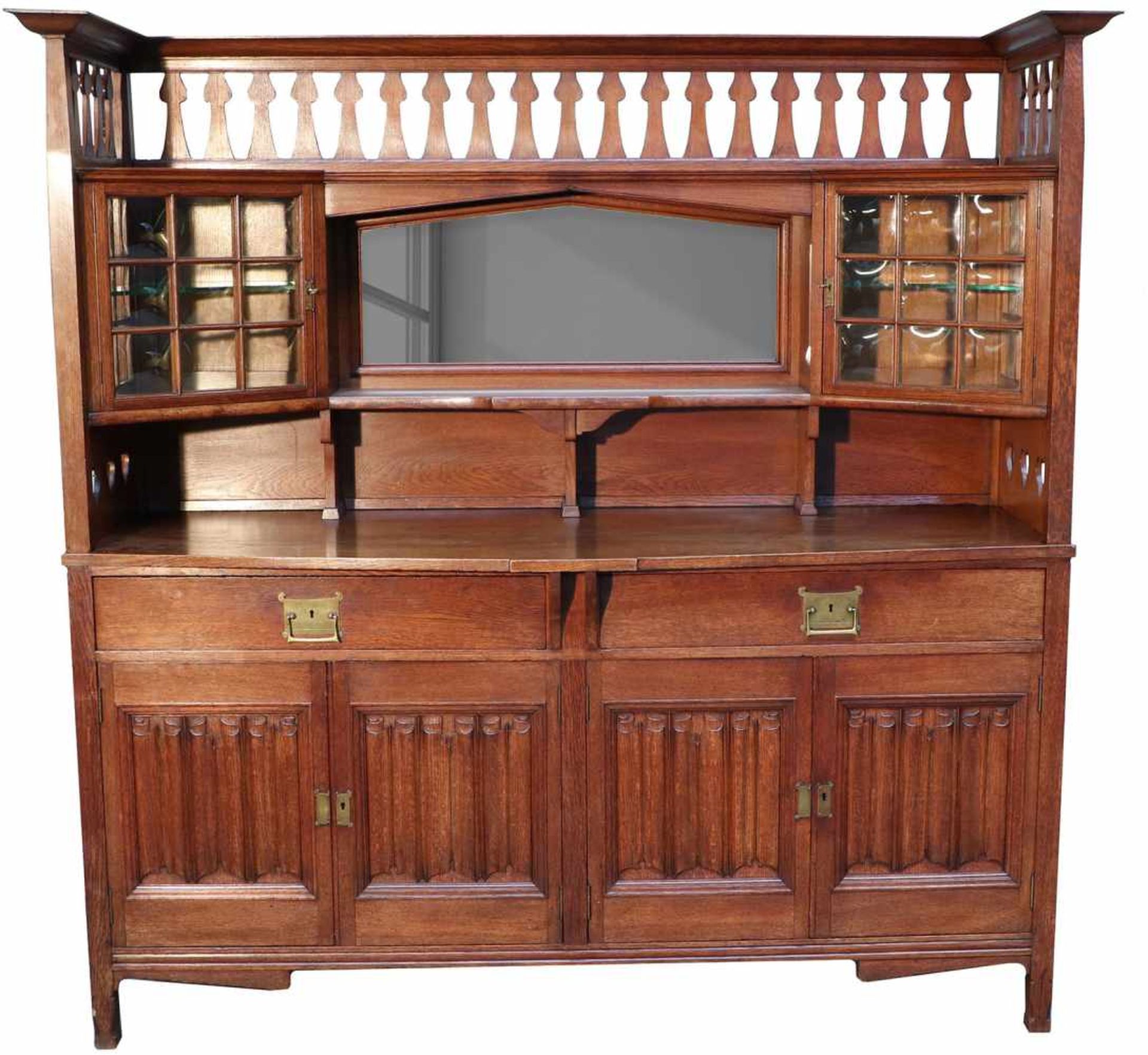 An Art Nouveau oakwood sideboard with glass- and carved linenfold panels. Circa 1910.