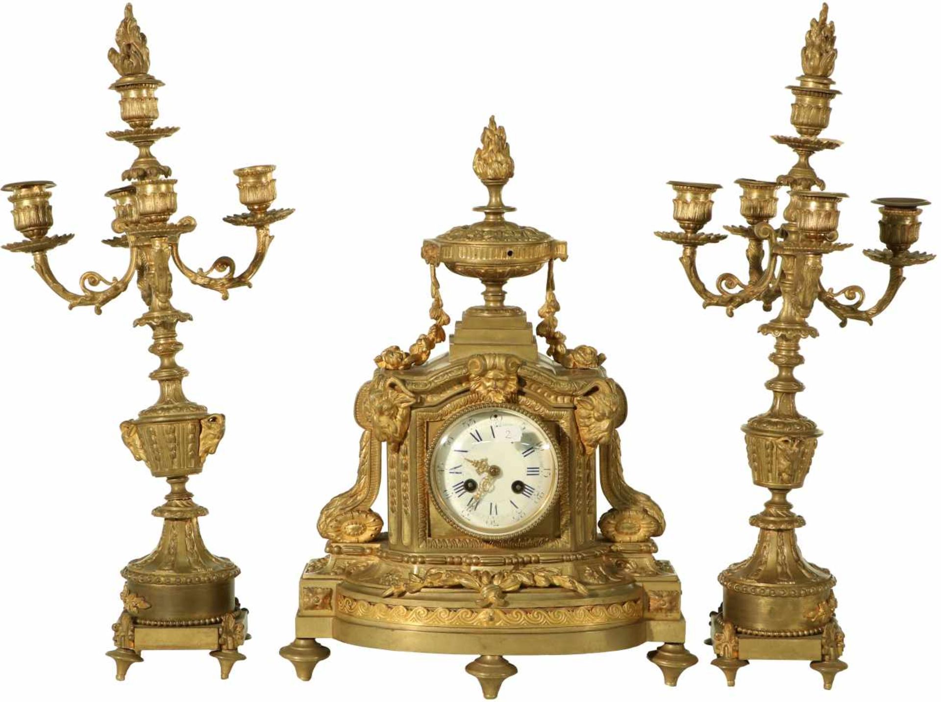 A bronze clock with enamel dial face and two additional candles. France, late 19th century.