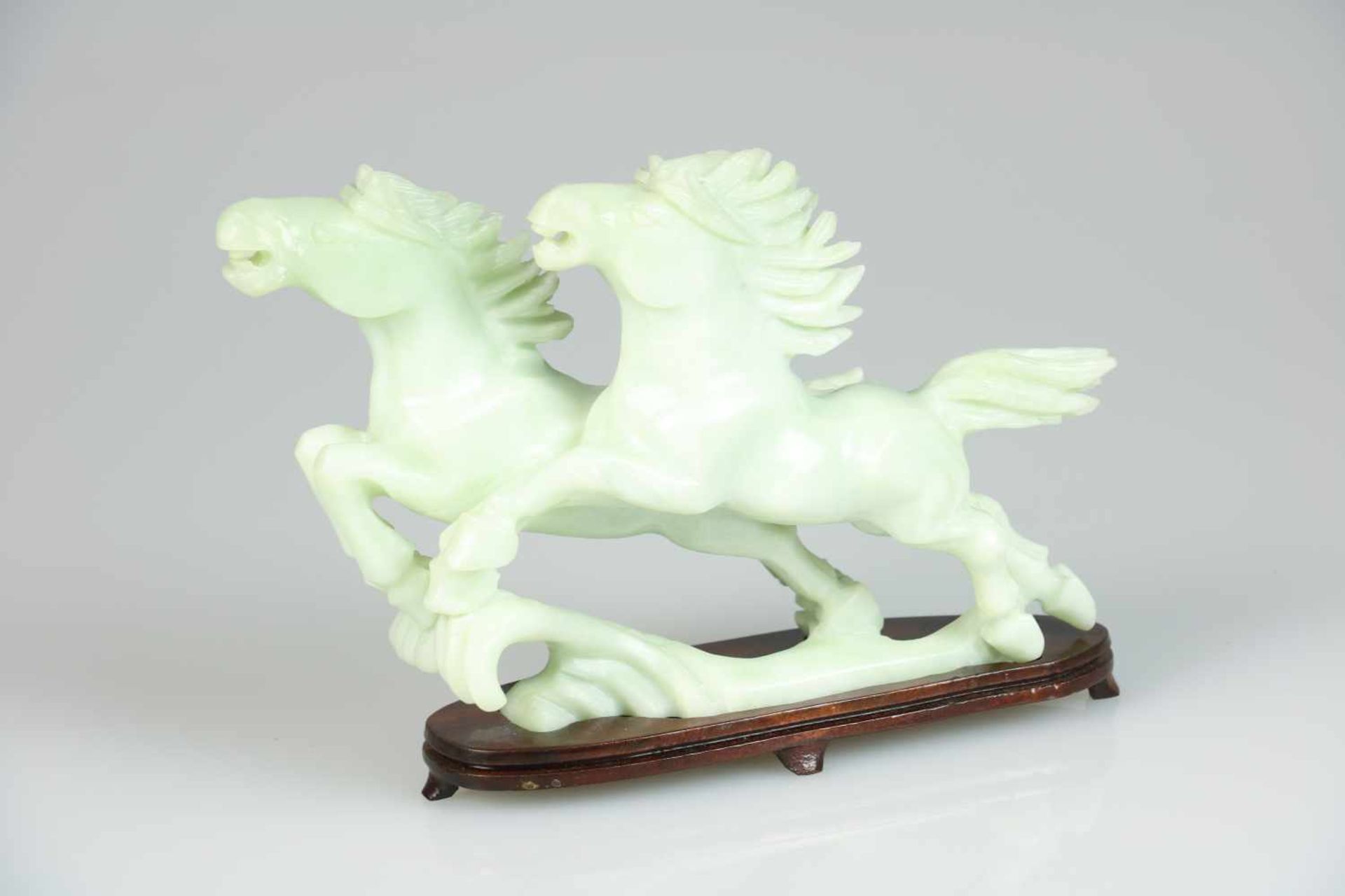 Een spekstenen sculptuur voorstellende twee rennende paarden. China, eind 20e eeuw. Afm. 19,5 x 17,5