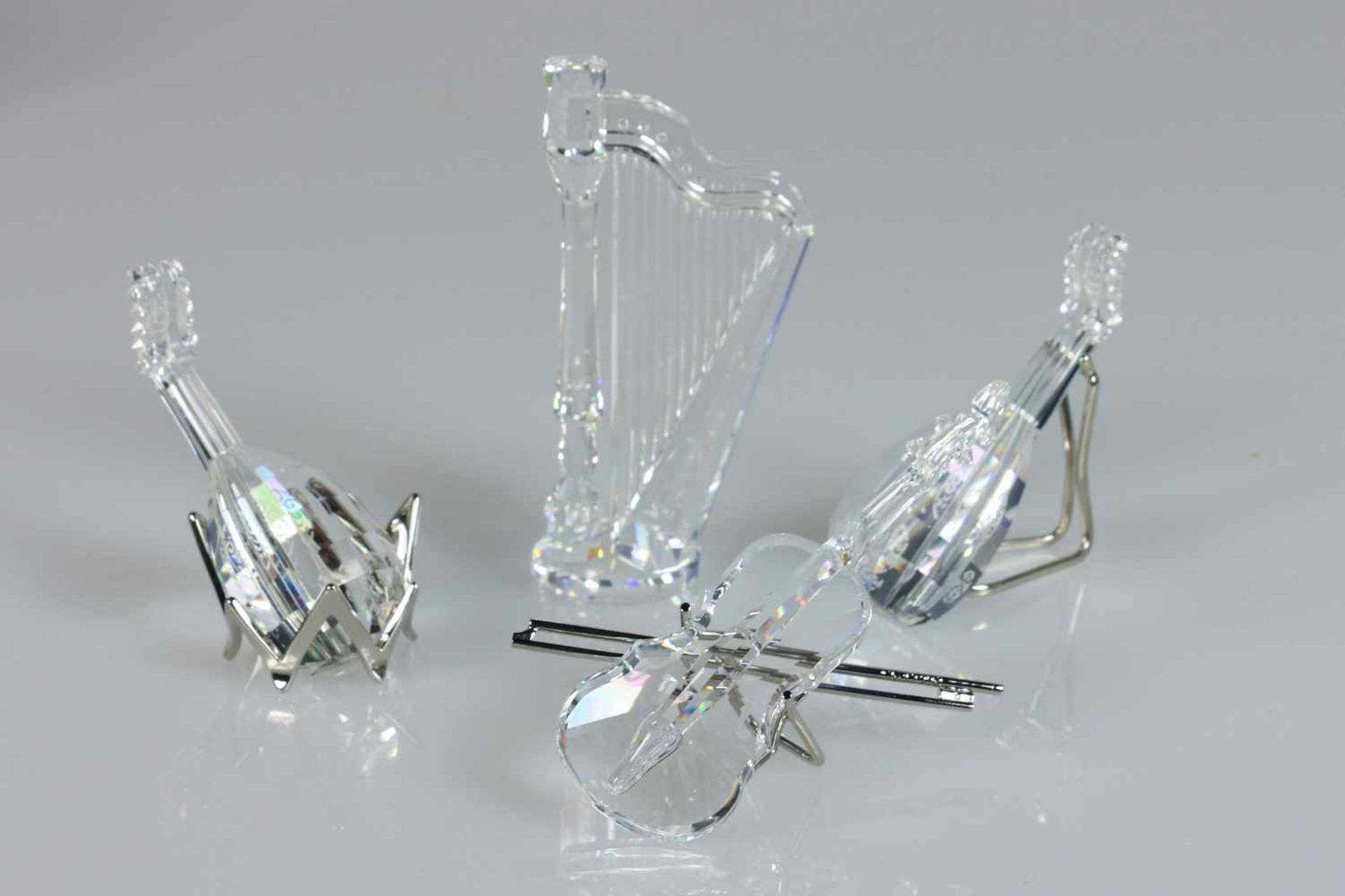 (4) delig lot muziekinstrumenten, Swarovski, 20e eeuw. Waaronder een harp, een viool en twee luiten.